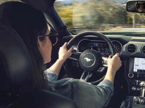 2023 Ford Mustang view of woman driving and holding steering wheel