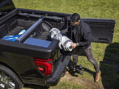 2024 Ford F-150 view of man loading supplies into bed of truck 